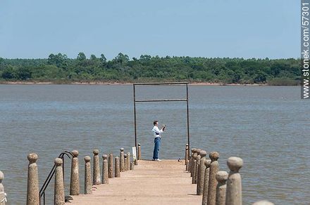 Tourist taking pictures of the river Uruguay. - Department of Paysandú - URUGUAY. Photo #57301