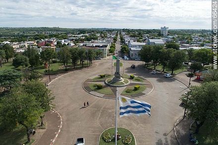 Vista aérea de la Plaza Batlle y Ordóñez, su obelisco y la bandera uruguaya - Departamento de Artigas - URUGUAY. Foto No. 66424