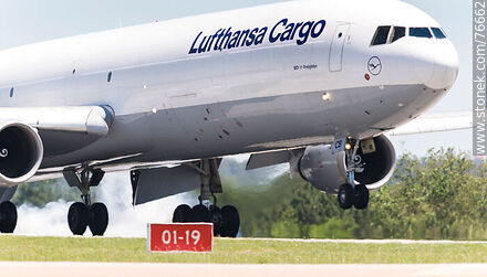 Lufthansa Cargo MD-11 Freighter landing on runway 01-19. Smoke coming from the friction of the wheels against the ground. - Department of Canelones - URUGUAY. Photo #76662