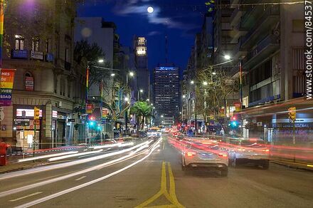 18 de Julio Avenue. Gaucho Tower. Trail of lights left by the traffic at dusk. The full moon - Department of Montevideo - URUGUAY. Photo #84537